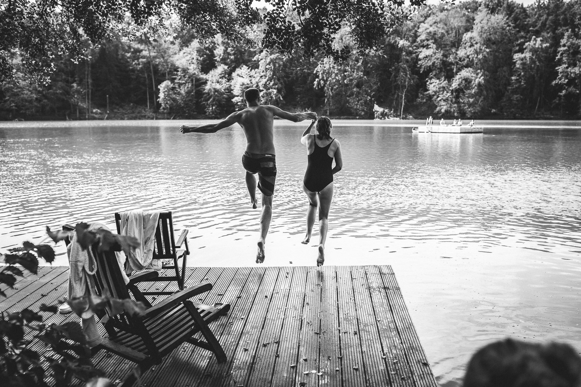 Hochzeitsreportage am See - Brautpaar springt vom Steg ins Wasser