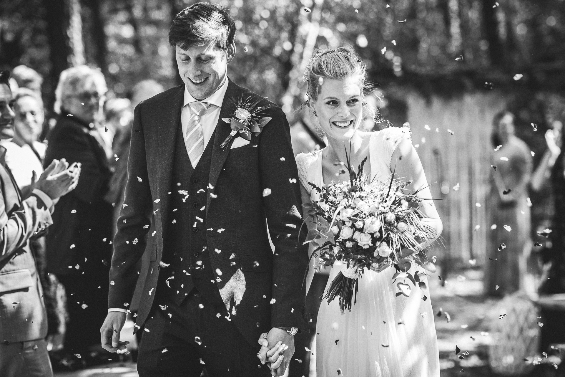 Brautpaar im Blütenregen bei der Hochzeit im Wald mit einem Hochzeitsfotografen aus Berlin.