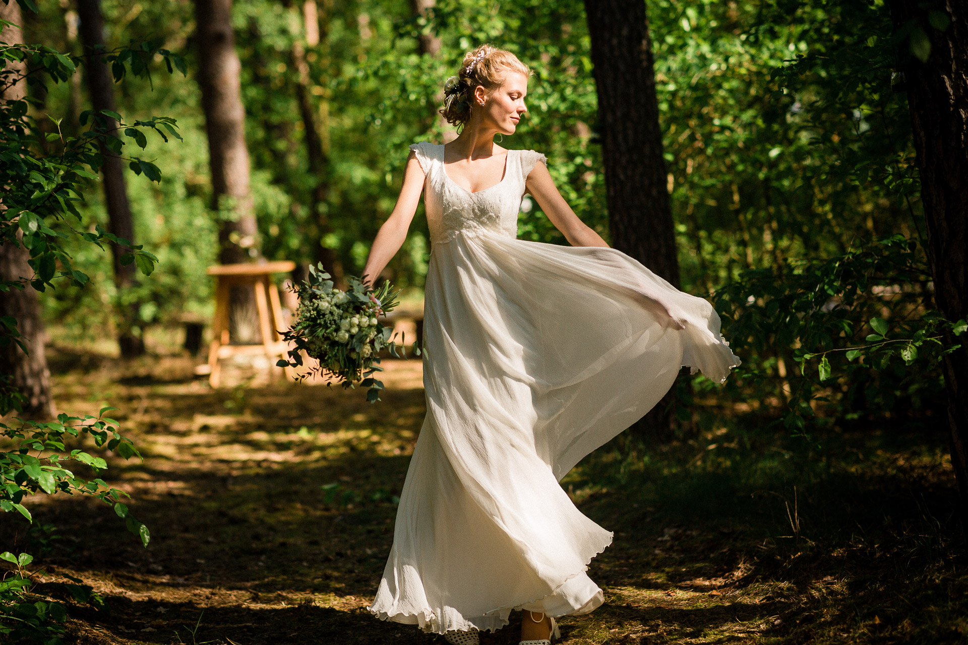 Braut dreht sich im Brautkleit bei Waldhochzeit